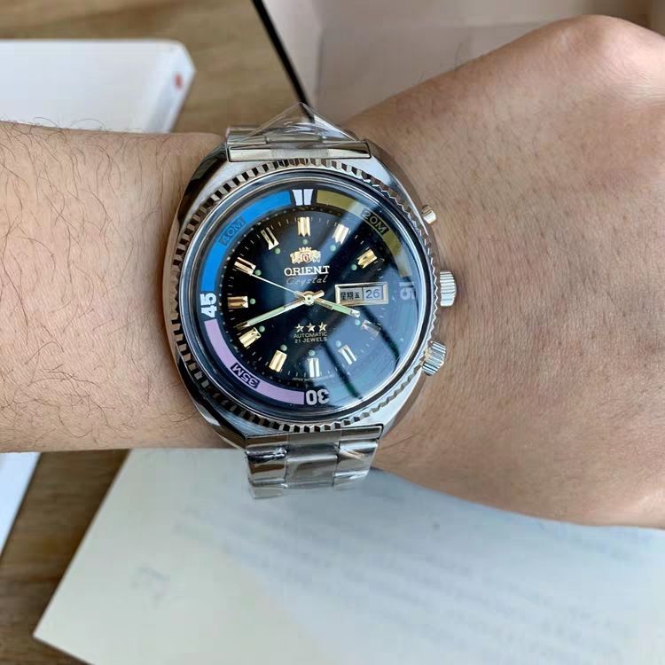 Blue dial Orient Crystal automatic diver with a multicolor bezel, worn on a wrist